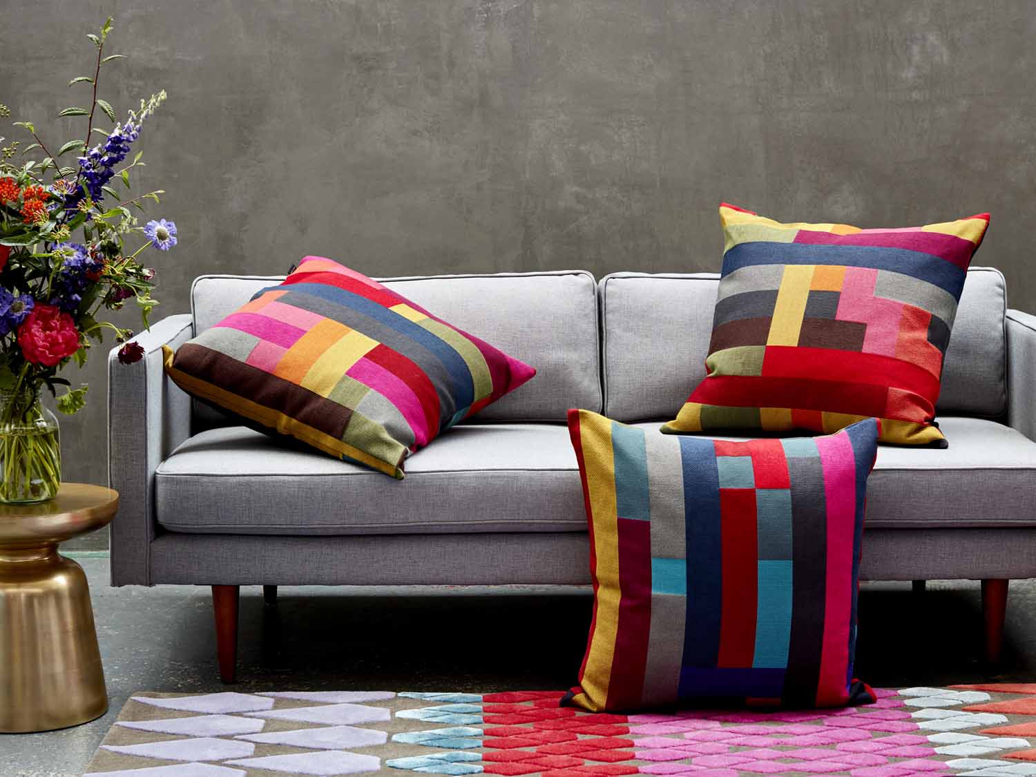серый диван с разноцветными подушками